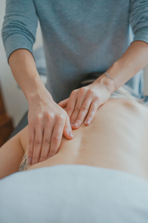 acupuncturist palpating the back of a patient